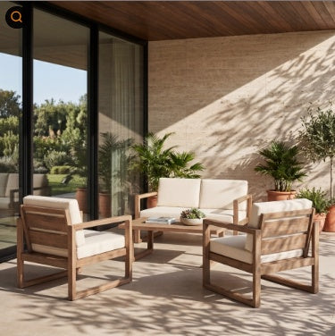 A 4-piece outdoor patio conversation set made of light brown wood with cream cushions, arranged on a covered patio with a matching coffee table.